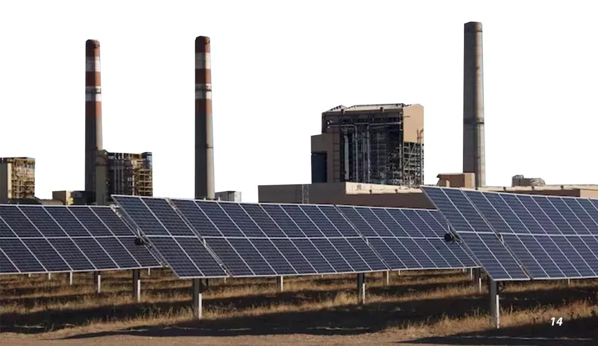 Solar panel array beside an industrial plant